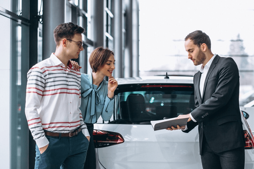 A sales professional showing a couple vehicle options
